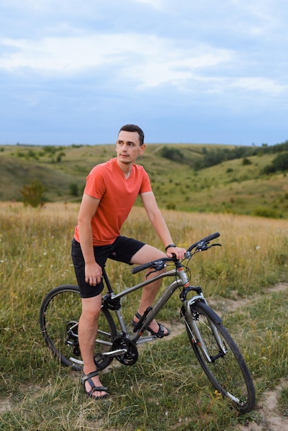 Ein junger Mann auf einem Fahrrad steht mitten auf dem Weg und wartet darauf, weiterzufahren