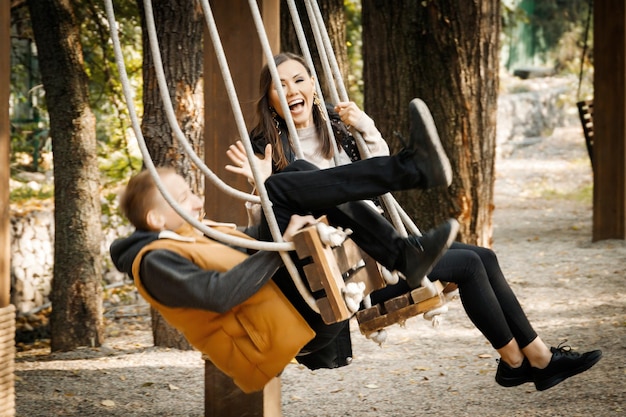 Ein junger Mann bei einem Date im Park drehte sich auf einer Schaukel um Ein lustiges Date