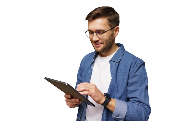 Ein junger Mann benutzt zu Hause ein Tablet in leichter, lässiger Kleidung und konzentriert sich auf digitale Inhalte