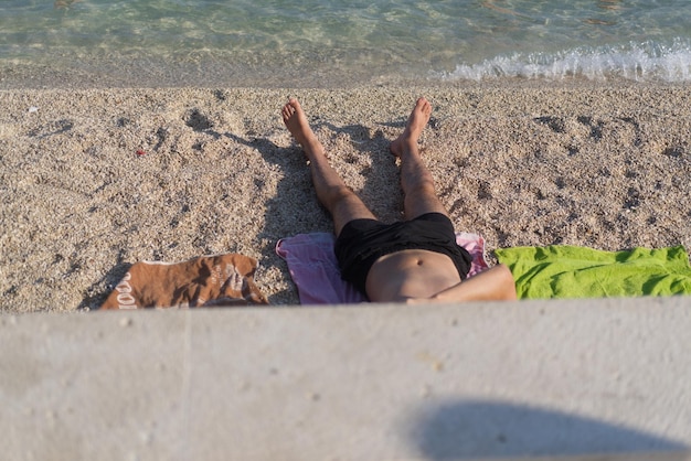 Foto ein junger mann, der sich am strand in kroatien sonnt