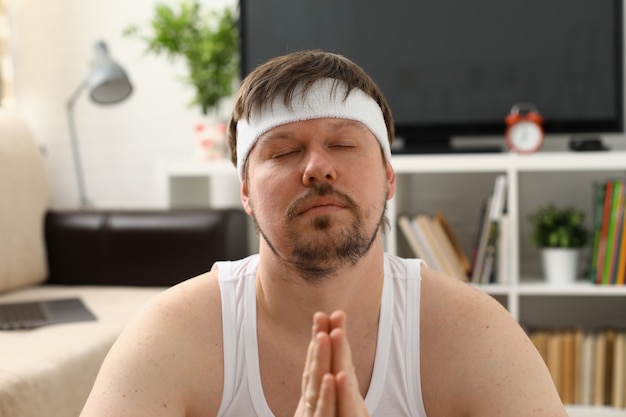 Ein junger Mann, der Yoga und Pilates praktiziert