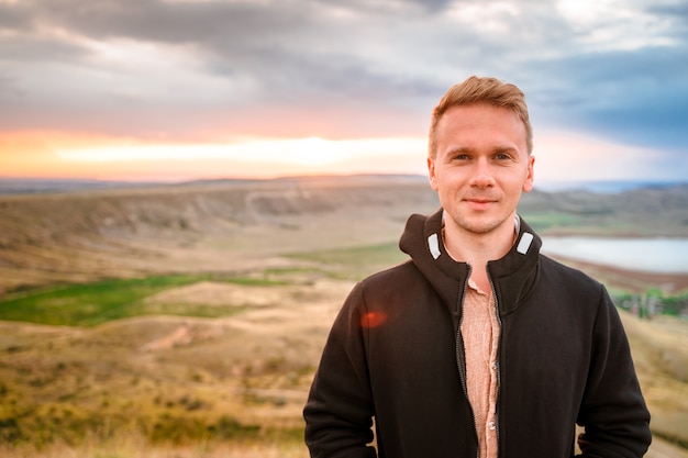 Ein junger Mann eroberte im Morgengrauen den Gipfel des Berges Wunderschöne Berglandschaft mit Hang