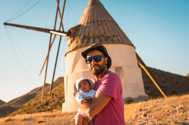 Ein junger Mann genießt mit seinem Sohn im Naturpark Cabo de Gata, einer Mühle in der Stadt San Jose, Almeria