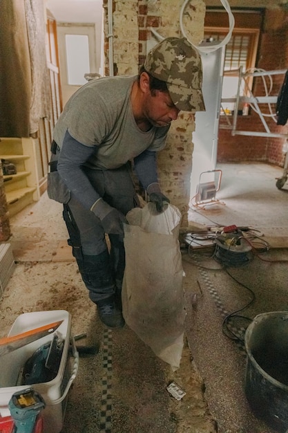 Ein junger Mann hält einen Beutel mit Bauabfällen drinnen