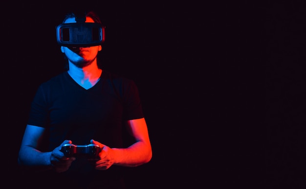 Ein junger Mann in der Virtual-Reality-Brille, der Videospiele spielt