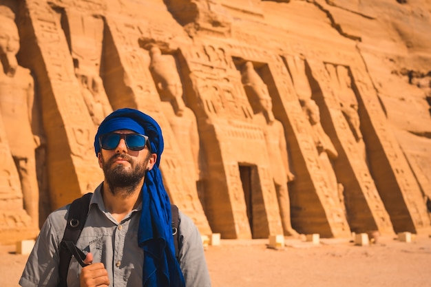 Ein junger Mann in einem blauen Turban und einer Sonnenbrille im Tempel von Nefertari in der Nähe von Abu Simbel in Südägypten in Nubien am Nassersee. Tempel des Pharao Ramses II., Reiselebensstil