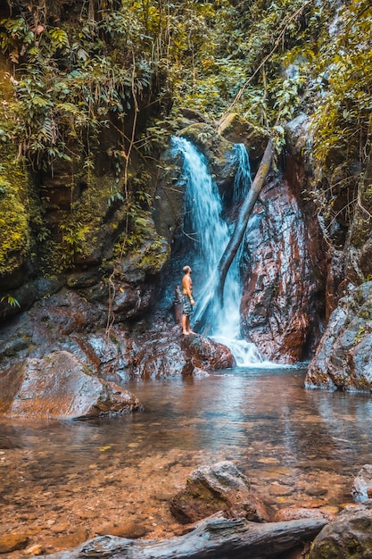 Ein junger Mann in einem Wasserfall des Nationalparks Cerro Azul Meambar Panacam in Yojoa, Honduras