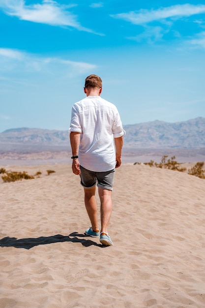 Ein junger Mann in einem weißen Hemd spaziert durch die malerische Wüste im Death Valley