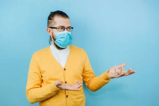 Ein junger Mann in einer medizinischen Maske auf einem Blau