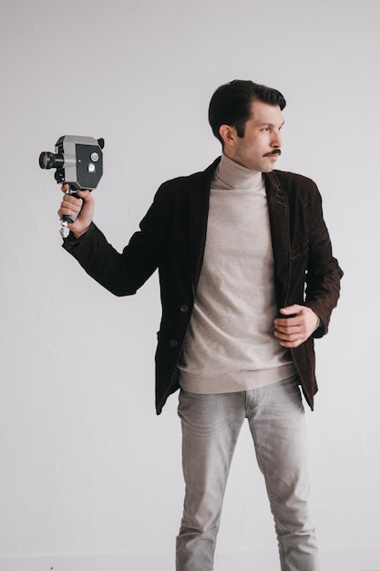 Foto ein junger mann in jeans und jacke posiert im studio vor einer weißen wand