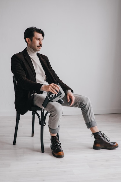 Foto ein junger mann in jeans und jacke posiert im studio vor einer weißen wand