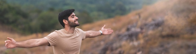 Foto ein junger mann mit ausgestreckten armen steht an land