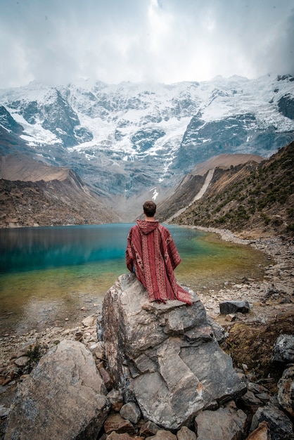 Ein junger Mann mit einem Poncho im Urlaub in Laguna Humantay Peru