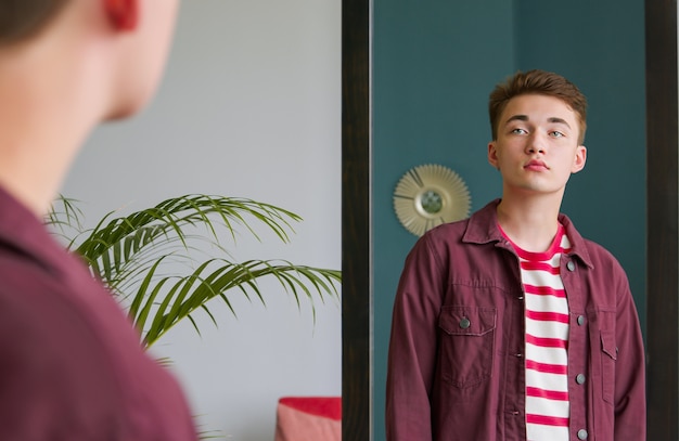 Foto ein junger mann schaut in den spiegel. mach dich bereit für ein date.