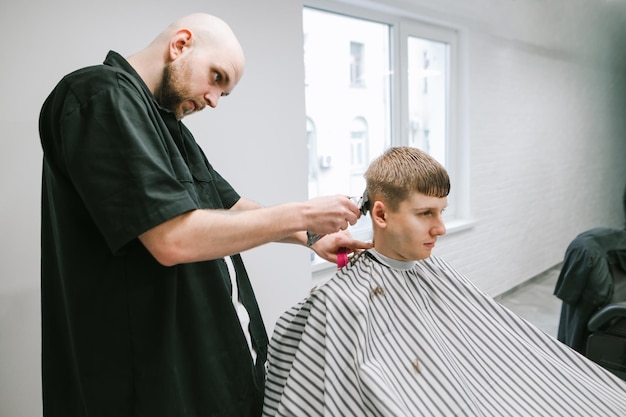 Ein junger Mann schneidet sein Barber-Barbershop-Konzept