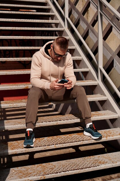 Ein junger Mann sitzt auf den Stufen im urbanen Lifestyle-Foto der Stadt