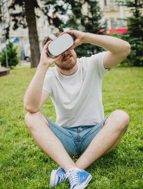 Ein junger Mann spielt ein Spiel mit einer Virtual-Reality-Brille auf der Straße.