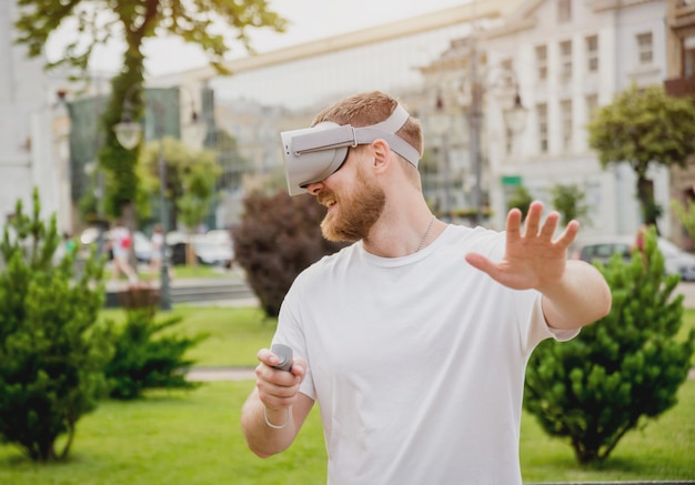 Ein junger Mann spielt ein Spiel mit einer Virtual-Reality-Brille auf der Straße.