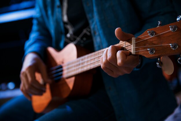 Ein junger Mann spielt Gitarre im Sitzen