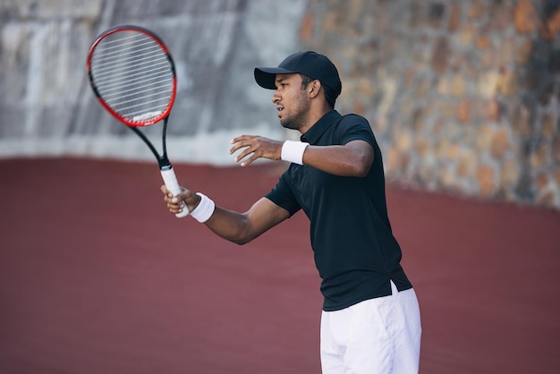 Ein junger Mann spielt Tennis.