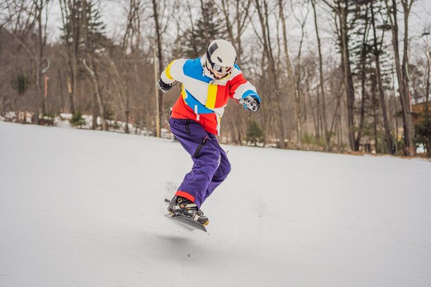 Ein junger Mann springt mit einem Snowboard in den Bergen