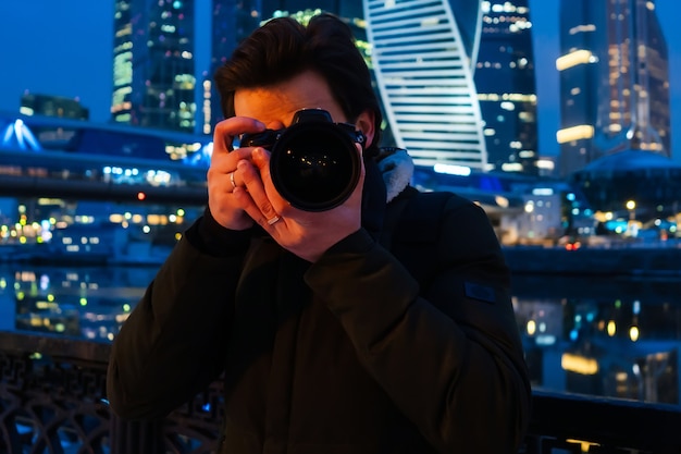 Ein junger Mann steht im Hintergrund der Stadt Moskau und schaut in die Kamera