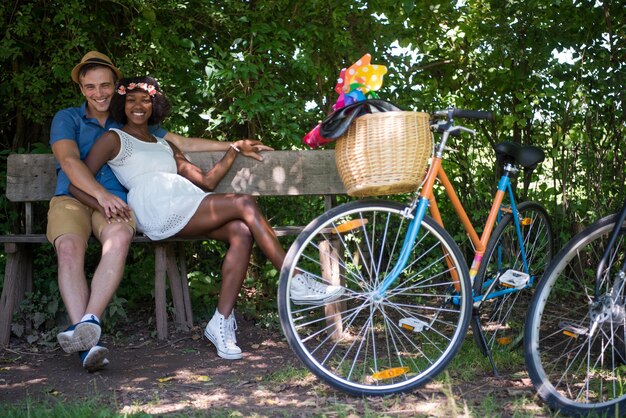 ein junger Mann und ein schönes afroamerikanisches Mädchen, das an einem sonnigen Sommertag eine Radtour in der Natur genießt