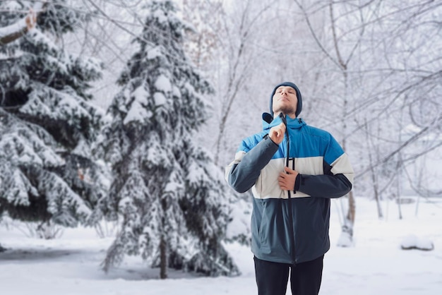 Ein junger Mann zog warme Kleidung der Wintersnowboardjacke an