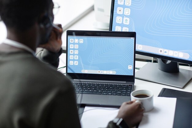 Ein junger schwarzer Mann benutzt einen Laptop mit blauem Desktop-Bildschirm