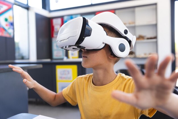 Ein junger Studenten aus zwei Rassen erforscht die virtuelle Realität mit einem Headset im Klassenzimmer