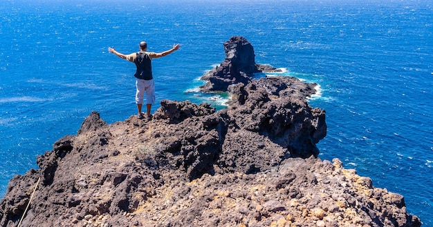 Ein junger Tourist auf dem Klippenpfad beim Abstieg zum schwarzen Sandstrand von Bujaren