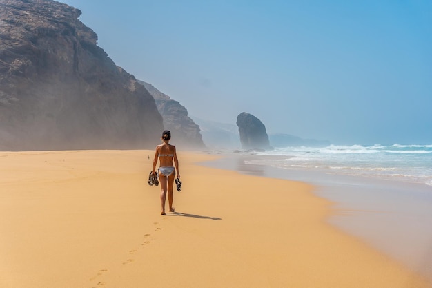 Ein junger Tourist, der allein am wilden Strand Cofete im Naturpark von Jandia spazieren geht