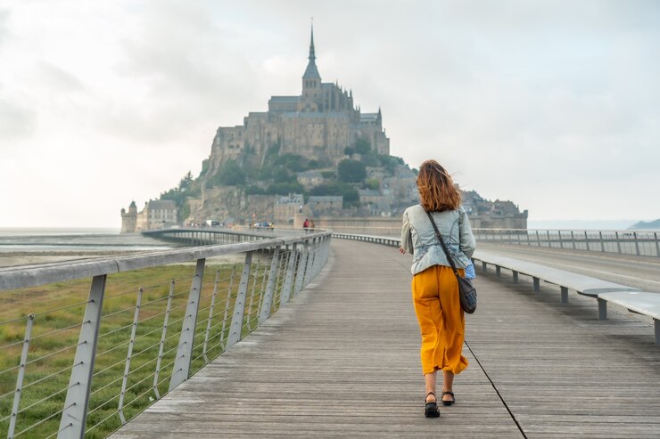 Foto ein junger tourist, der den berühmten mont saint-michel im département manche, normandie, france . besucht