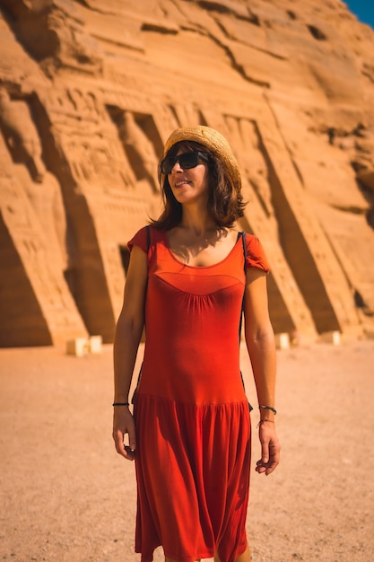 Ein junger Tourist in roter Kleidung, der den Tempel von Nefertari in der Nähe von Abu Simbel in Südägypten in Nubien am Nassersee besucht. Tempel des Pharao Ramses II., Reiselebensstil