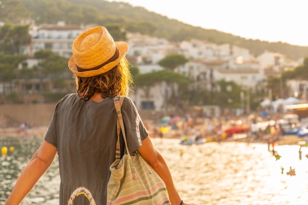 Ein junger Tourist mit Hut bei Sonnenuntergang an der Küste von Tamariu in der Stadt Palafrugell. Girona, Costa Brava im Mittelmeer