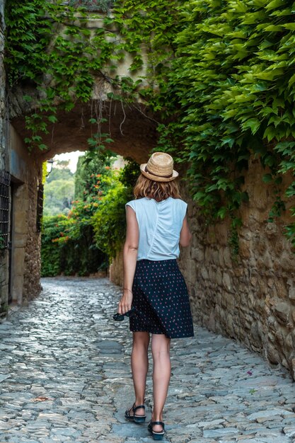 Ein junger Tourist zu Fuß durch die Straßen der mittelalterlichen Stadt Peratallada, Altstadt, Girona an der Costa Brava von Katalonien im Mittelmeer?