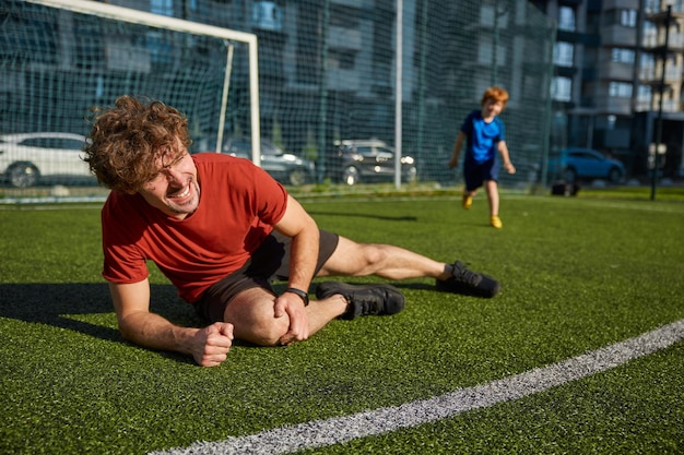 Ein junger Vater-Fußballspieler verletzte sich beim Spiel mit seinem Sohn am Bein