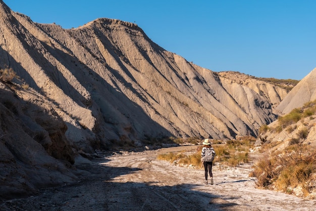 Ein junger Wanderer mit Rucksack in der Wüste von Tabernas, Provinz AlmerÃƒÃ‚Âa, Andalusien. Auf einer Wanderung in der Rambla del Infierno
