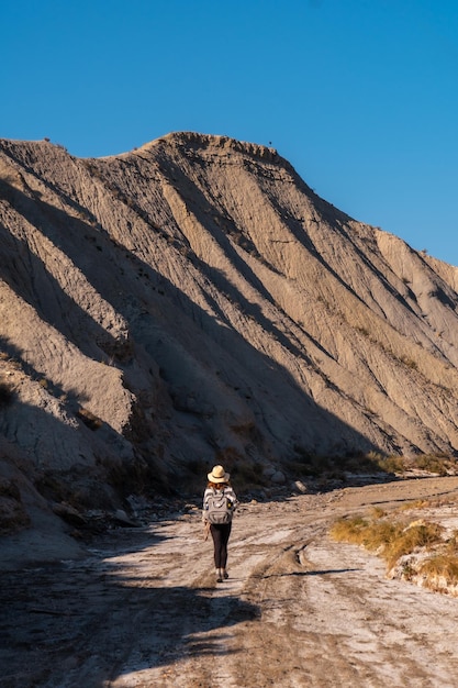 Ein junger Wanderer mit Rucksack und Hut in der Wüste von Tabernas, Provinz AlmerÃƒÃ‚Âa, Andalusien. Auf einer Wanderung in der Rambla del Infierno