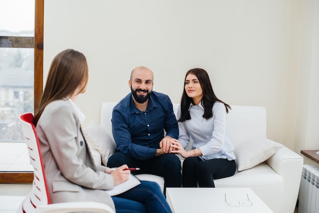 Ein junges glückliches Ehepaar von Männern und Frauen spricht bei einer Therapiesitzung mit einem Psychologen. Psychologie.