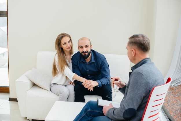 Ein junges, glückliches Ehepaar von Männern und Frauen spricht während einer Therapiesitzung mit einem Psychologen. Psychologie.