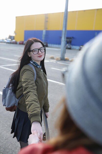 Ein junges Hipster-Mädchen reitet auf einem Skateboard Mädchen Freundinnen für einen Spaziergang in der Stadt mit einem Skateboard Frühlingssport auf der Straße mit einem SkateboardxA