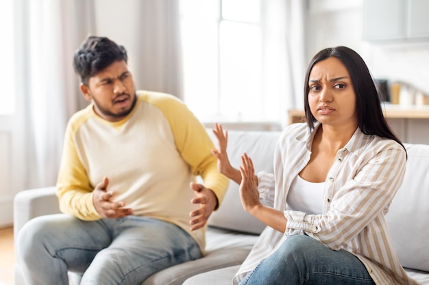 Ein junges indisches Paar streitet sich im Wohnzimmer