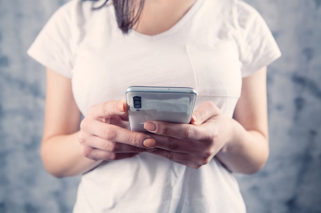 Foto ein junges mädchen, das ein telefon in ihren händen hält