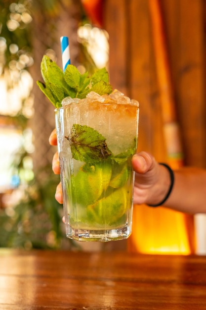 Ein junges Mädchen erfrischt sich im Sommer mit einem Mojito-Cocktail im Urlaub