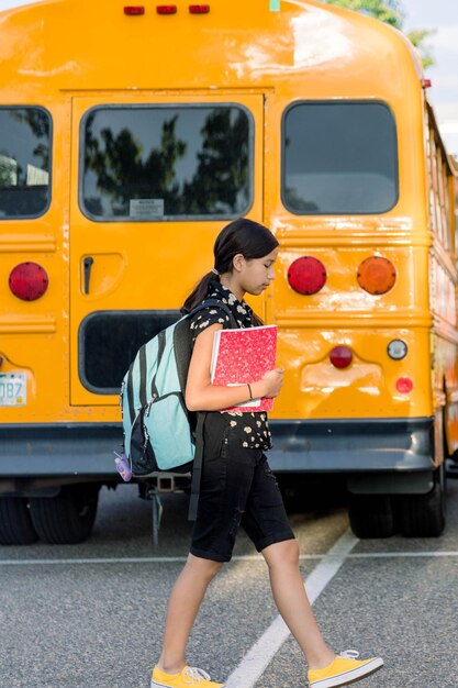 Foto ein junges mädchen geht in der nähe eines schulbusses zur schule