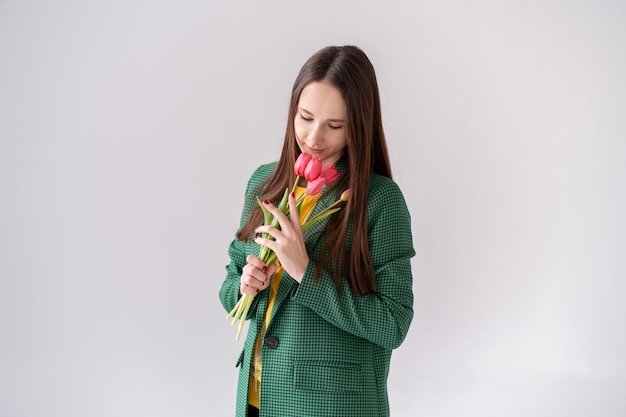 Ein junges Mädchen hält einen Strauß Tulpen in den Händen und bewegt ihn zur Kamera Kaukasische Frau demonstriert die Produkte eines kleinen Familienblumenunternehmens