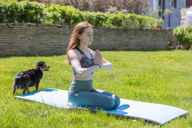 Ein junges Mädchen hält sich an einen gesunden Lebensstil und macht Yoga im Freien