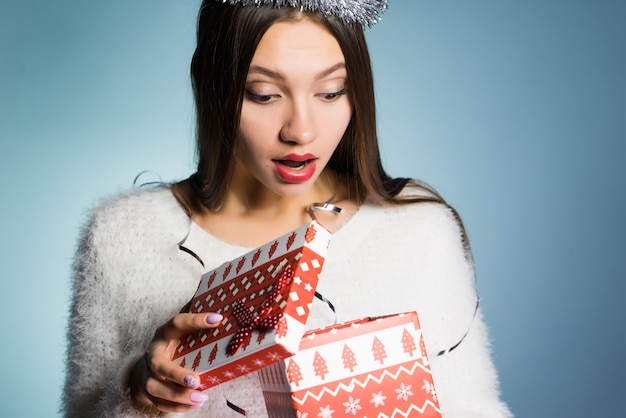 Ein junges Mädchen hat ein Geschenk zum neuen Jahr bekommen und sieht überrascht aus