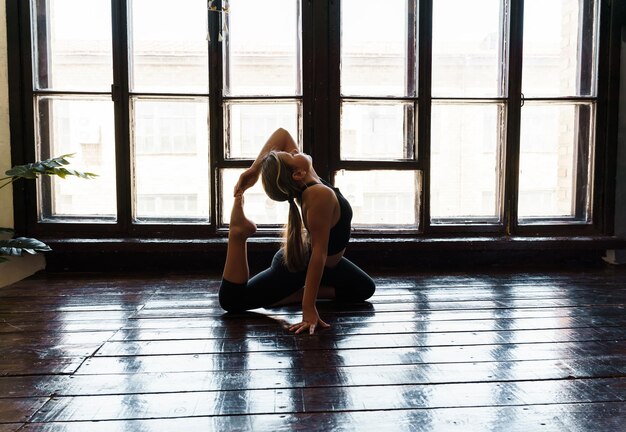 Ein junges Mädchen in Sportbekleidung macht Yoga-Fitness zu Hause Sport zu Hause Stretching